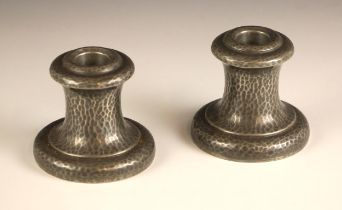 A pair of Tudric for Liberty Arts & Crafts planished pewter candlesticks, each of waisted circular