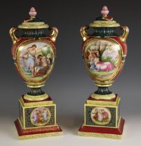 A pair of Vienna porcelain twin handled vases and covers, mid 19th century, each of urn form,