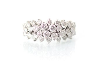 A stylised diamond cluster ring, the graduated round cut diamonds set within a raised claw set