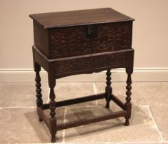 A 17th century carved oak bible box on stand, the rectangular moulded hinged cover opening to a