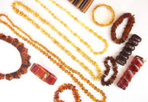 A selection of amber coloured jewellery, including a panelled 'amber' coloured bracelet, a