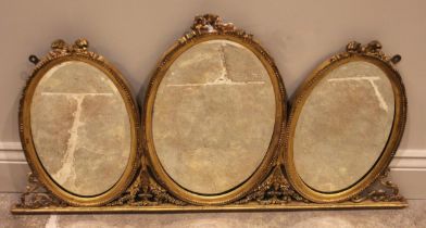 A 19th century giltwood and gesso ‘overmantel’ mirror, designed as three oval bevelled mirror