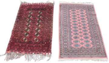 Two Iranian Bokhara pattern carpets, the octagonal gulls on a pink or red ground, 157cm x 96cm &