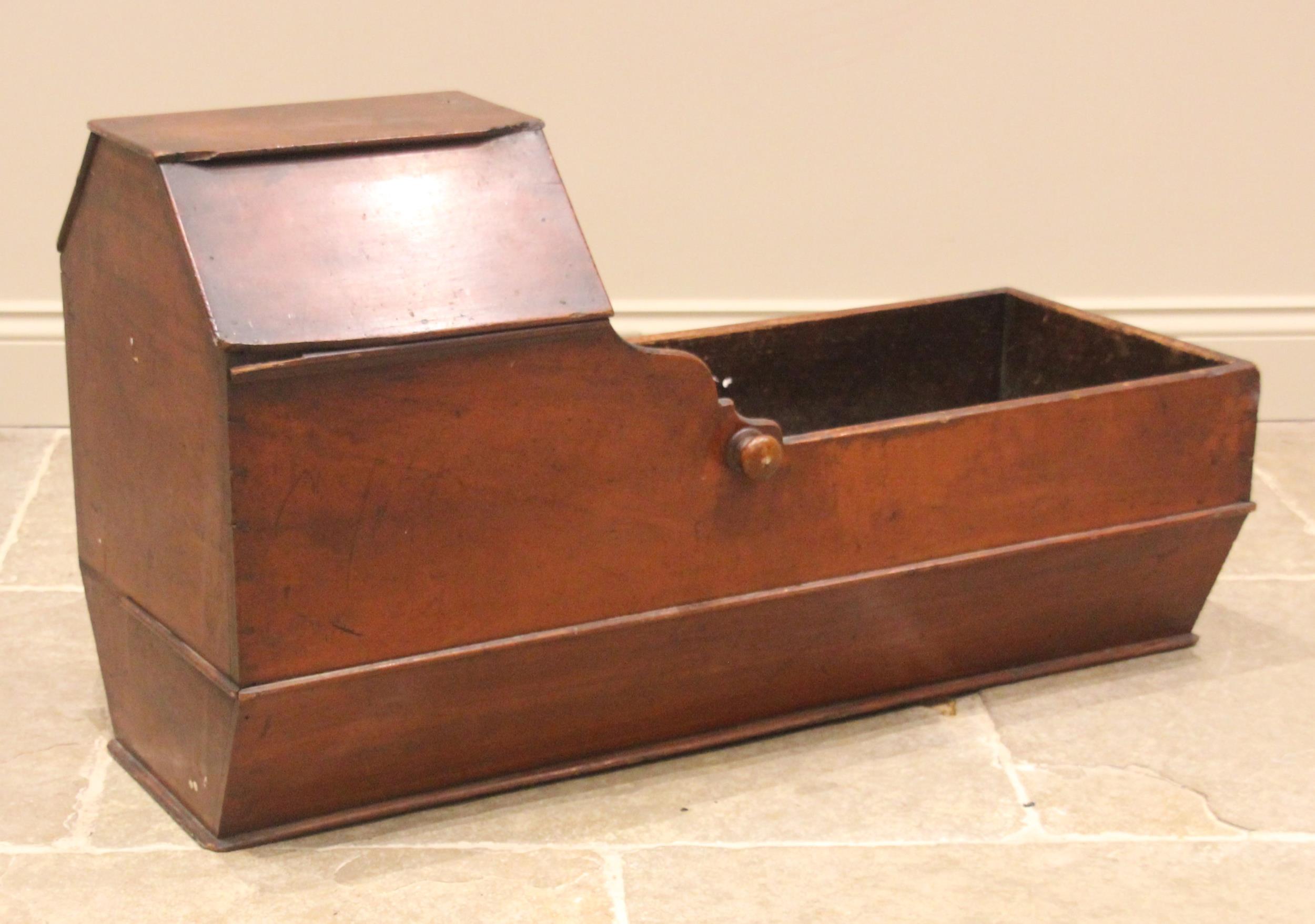 A 19th century stained pine cradle, of typical boat form, with angular canopy and ogee recess, above