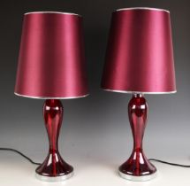 A pair of contemporary ruby glass table lamps, of baluster form with a spreading foot upon an