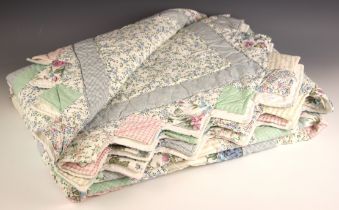 A patchwork quilt, late 20th century, comprised of floral, gingham and striped fabrics on a white