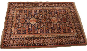 A Caucasian village rug, in orange, green and blue colourways, the central field with twin octagonal