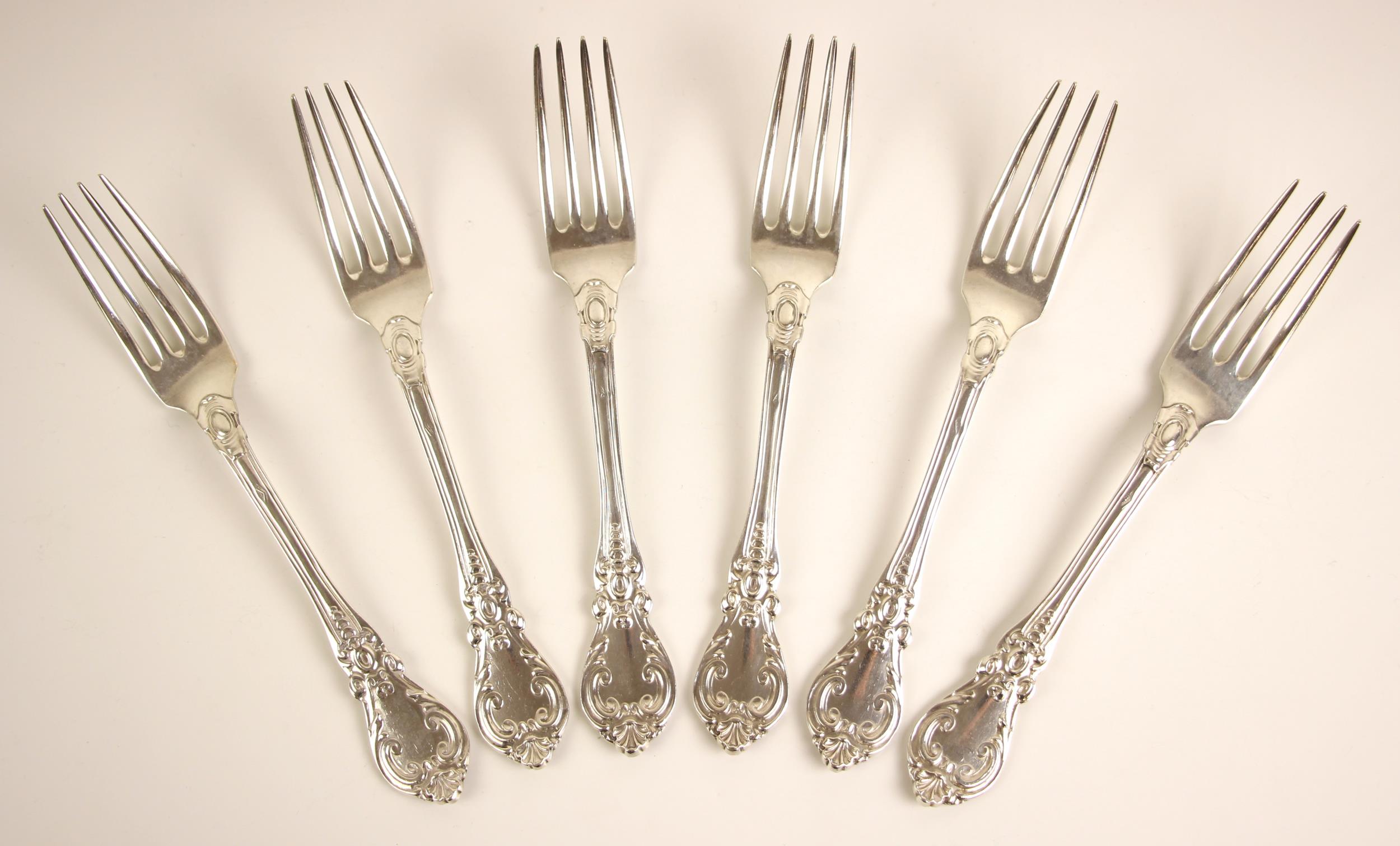 A set of six 19th century French silver table forks, the scrolling decorated spoon with initial to