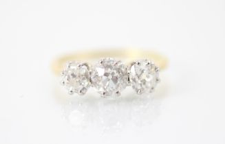 A 20th century diamond three stone ring, the central old cut diamond with smaller old cut diamond to