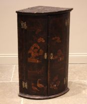 An 18th century chinoiserie lacquered bow front hanging corner cupboard, the twin doors applied with