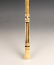 A carved whalebone scrimshaw walking cane, mid 19th century, of gently curved tapering form, the