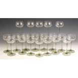 A collection of twenty hock glasses, 20th century, the bowl leading to a pale green stem, on a