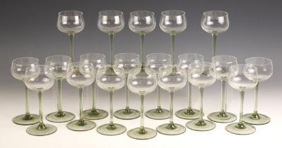 A collection of twenty hock glasses, 20th century, the bowl leading to a pale green stem, on a