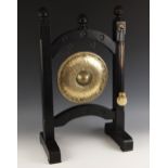 A brass dinner gong, 20th century, of planished form, supported by wooden frame, with beater, 68cm