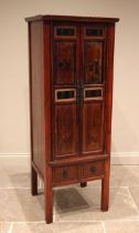 A Chinese red lacquer cabinet, late 20th century, the twin panelled doors painted with figures and