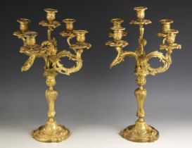 A pair of Rococo style gold painted five branch brass candelabra, 20th century, each branch modelled