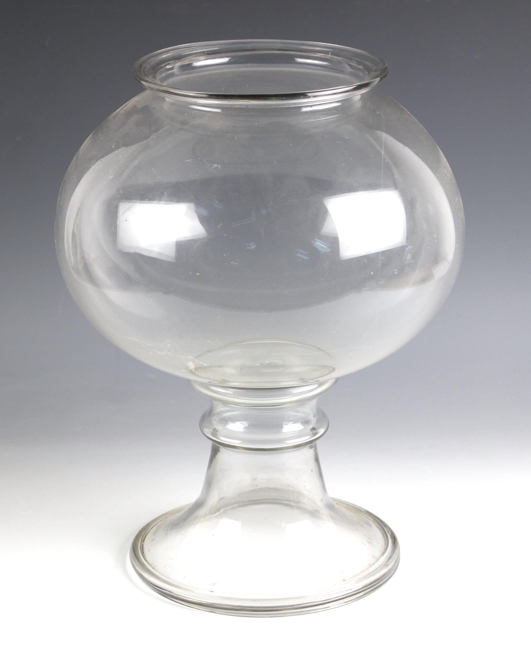 A glass leech jar, early 19th century, the compressed spherical body with flared rim, raised on an