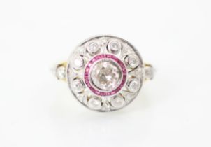 An Art Deco style diamond and ruby target ring, the central round cut diamond within a surround of