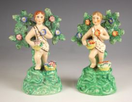 Two Walton Staffordshire bocage figures of putti, 19th century, modelled holding a basket of