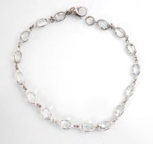 An aquamarine set bracelet, the sixteen oval cut stones within rub over white metal edge, with