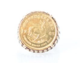 A 1/10 krugerrand coin set ring, the coin dated 1985 within a openwork 9ct mount and plain