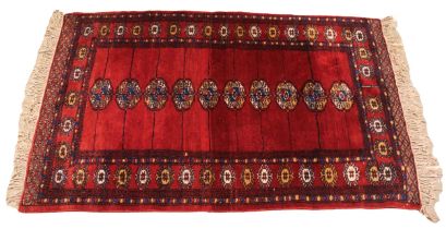 A Turkmen rug, hand knotted rug, the deep red ground with ten octagonal Bokhara type gulls, bordered