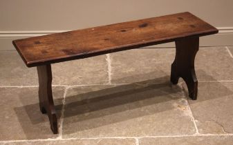 A stained pine bench, late 19th century, the rectangular top upon shaped 'U' cut trestle type