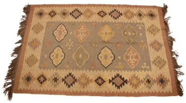 A Kilim rug, in subtle autumnal shades, the central field with eight lozenge shaped guls,