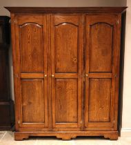 A Victorian style oak triple wardrobe, by Oakwood, Traditional Furniture, Chester, late 20th/early