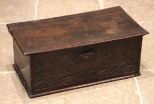 A 17th century carved oak bible box, the hinged cover opening to a vacant interior, above a front