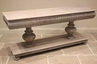 A contemporary limed oak console table in the Elizabethan style, the convex nulled frieze with