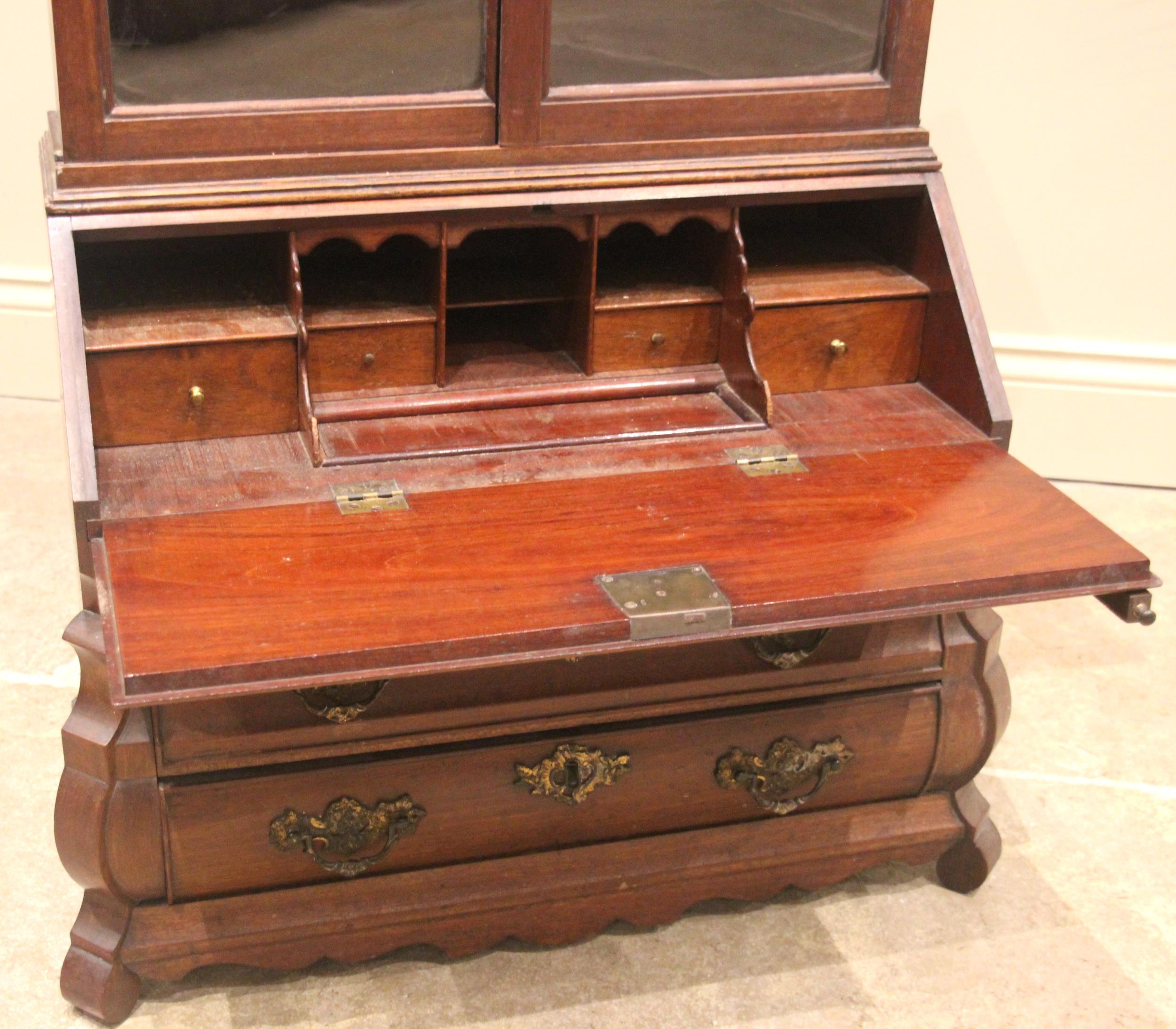 An 18th century Dutch walnut apprentice bombe bureau bookcase, the arched top with a carved crest - Image 2 of 4