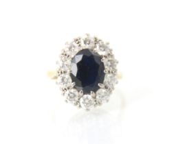 An Edwardian style sapphire and diamond cluster ring, the central oval cut sapphire claw set in