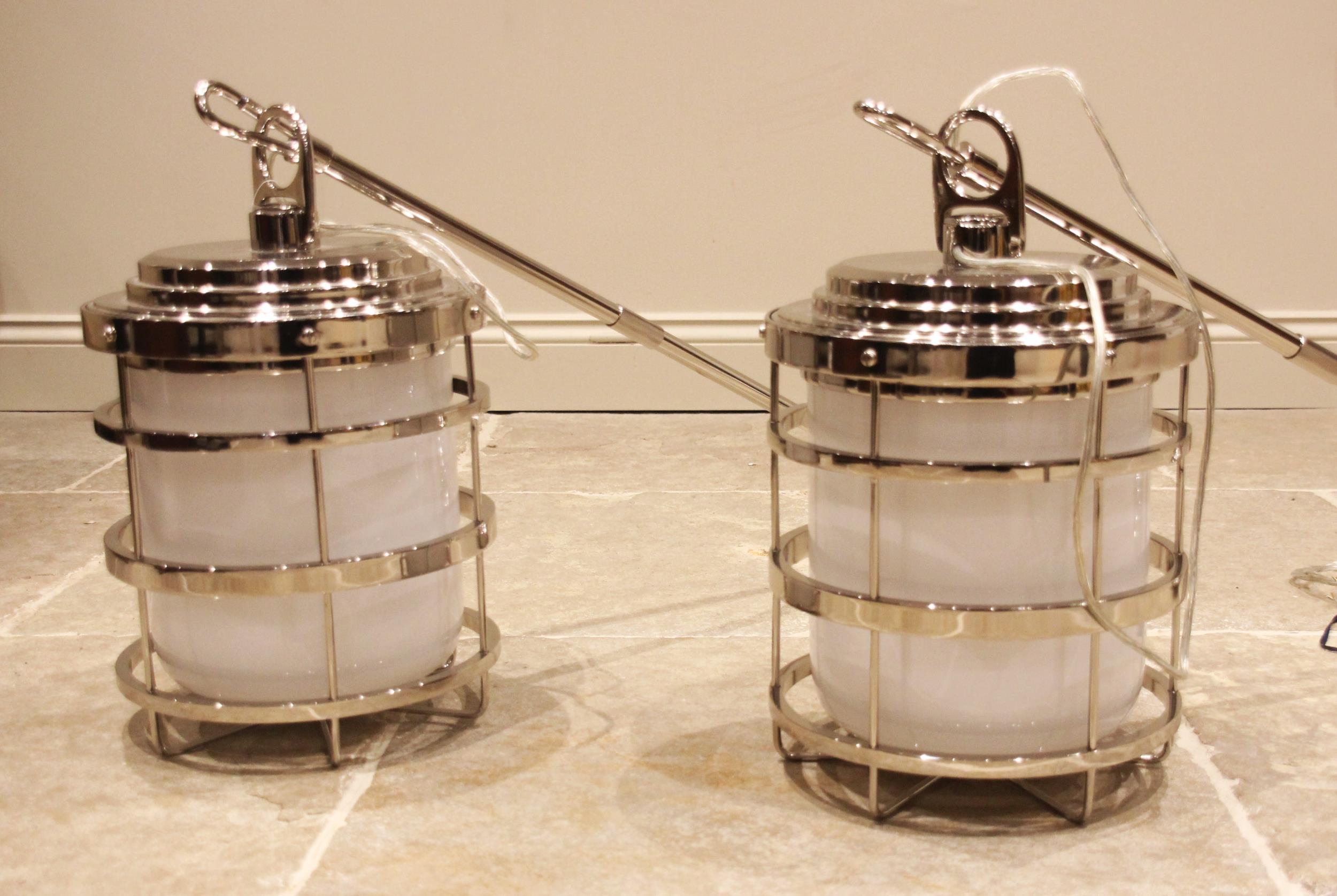 A pair of Ralph Lauren blue label New York chromed pendant ships lanterns, each with impressed