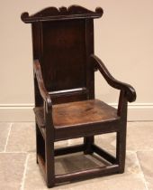 A 17th century oak Lancashire Wainscot chair, the panelled back with a shaped top rail extending
