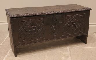 A 17th century carved oak six plank coffer, the hinged cover carved with geometric motifs within a