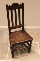 A 17th century joined oak back stool, with a shaped top rail, lath back and board seat upon block