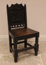 A 17th century style panel back oak hall chair, 19th century, the back panel carved with a hunting