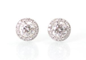 A pair of diamond stud earrings, the round cut diamond within a surround of further smaller round