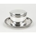 Silver biscuit tin on saucer