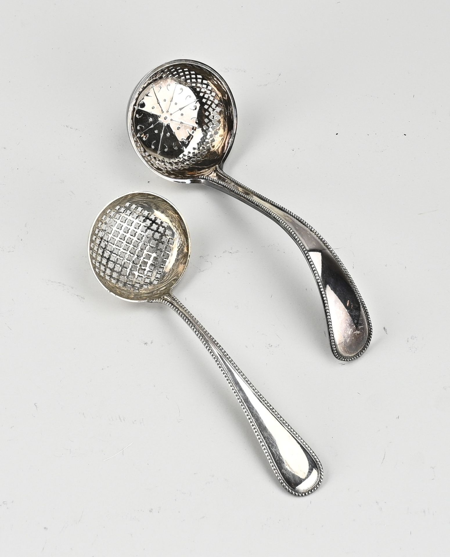 Two silver sprinkle spoons