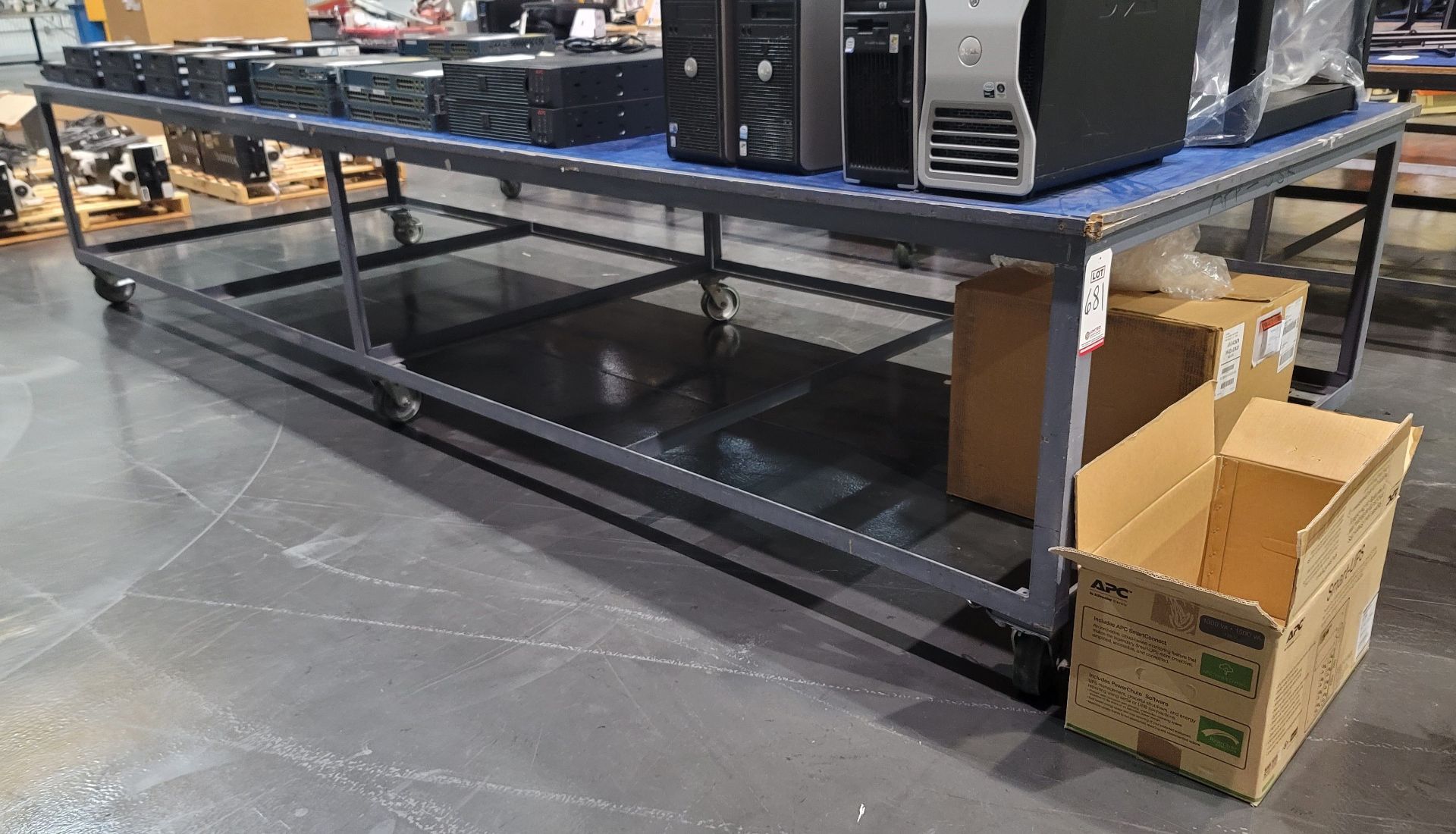 STEEL FRAME TABLE ON CASTERS W/ PARTICLE BOARD TOP COVERED BY 1/4