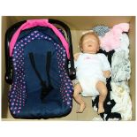 A unboxed Modern Doll with clothes & Car Seat.