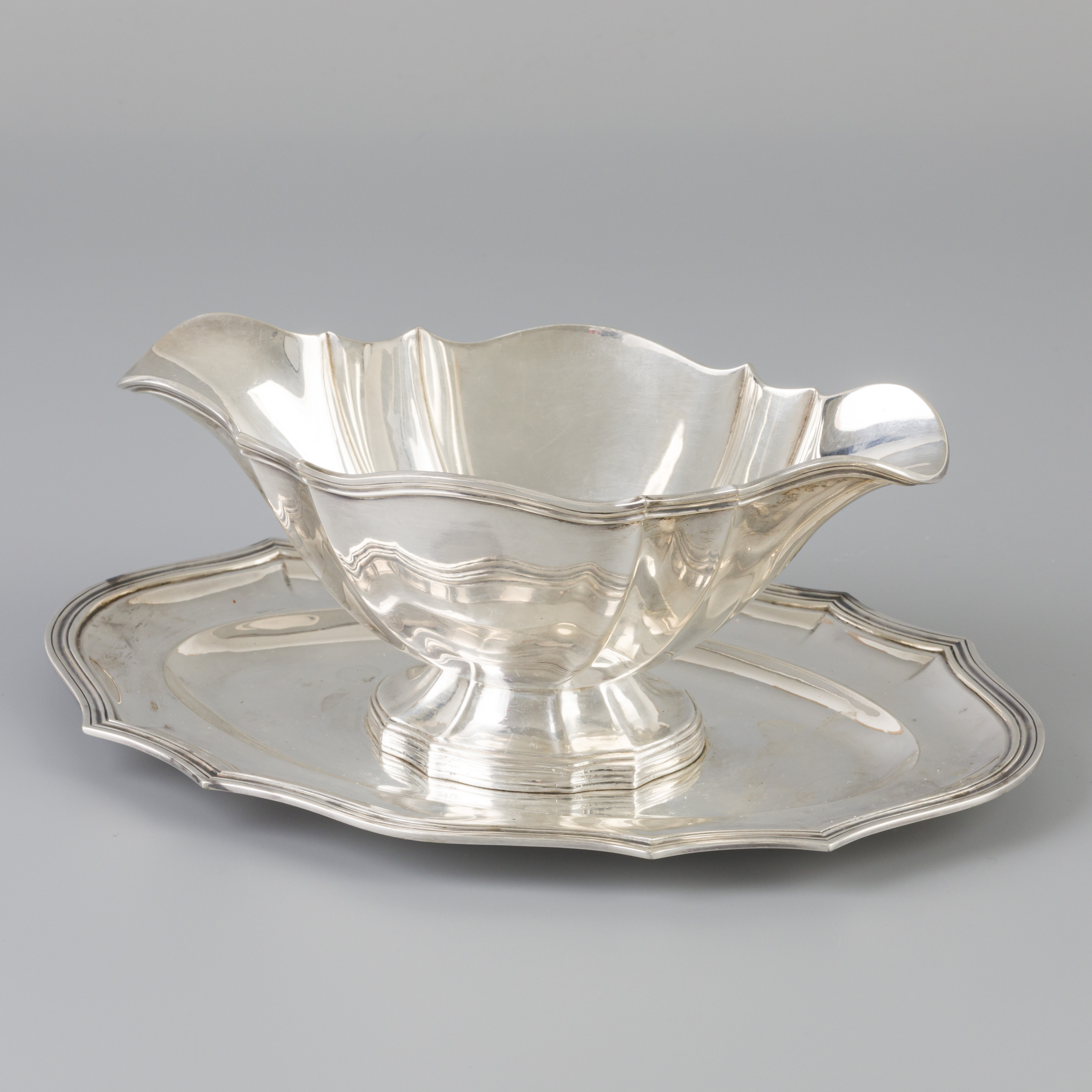 Sauce boat with silver saucer.