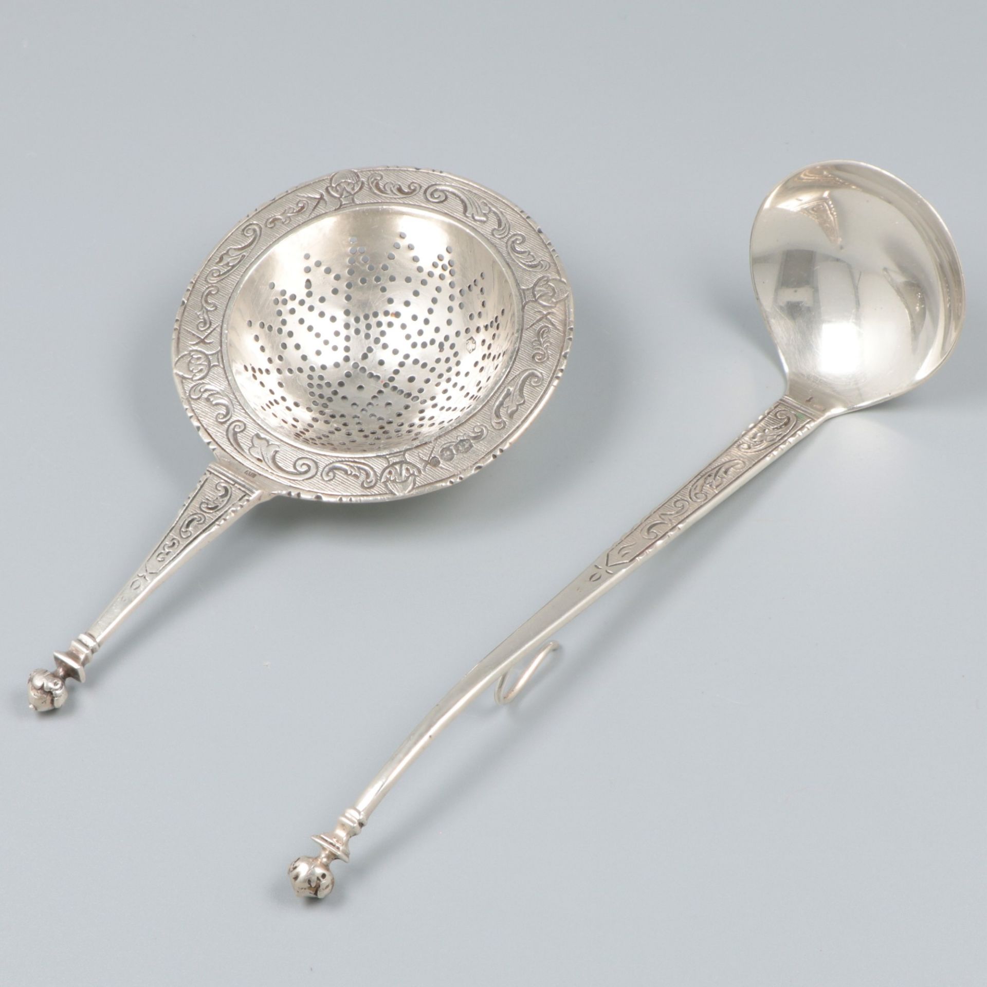 Tea strainer and cream spoon silver.