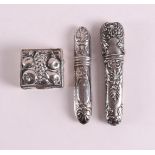 A second grade 835/1000 silver pill box and two needle cases, early 20th century, tot. 3x.