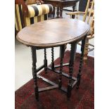 A gateleg table, England, early 20th century. Oak wood, oval top with turned cross leg, h 76 x l86 x