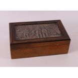 A rectangular walnut cigar box with second grade 835/1000 silver lid with relief decoration of the