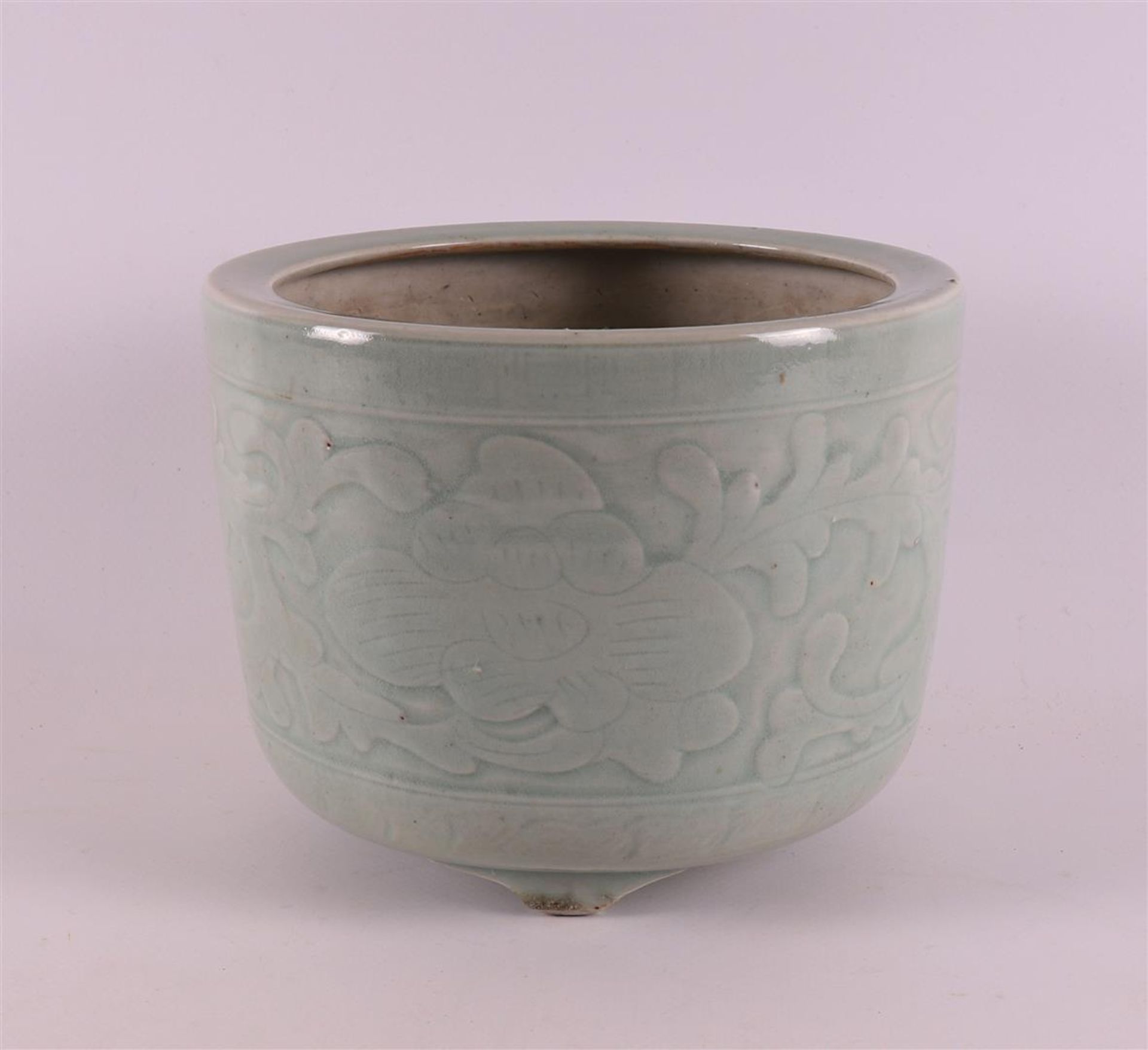 A celadon-coloured porcelain brush pot, China, Kangxi, around 1700. Relief floral decoration, h 13 x