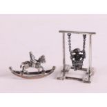 Etagere silver. A miniature girl on a swing and a rocking horse, 20th century, h 4.5 and 2.5 cm,
